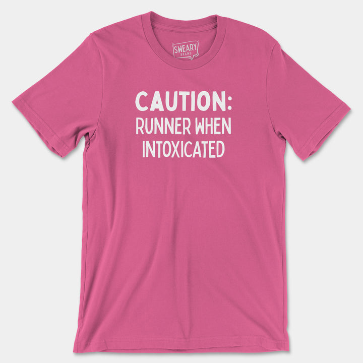 a pink shirt that says caution runner when intoxicated